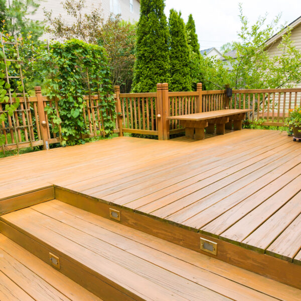 Wooden deck of family home. A wooden deck with steps and bench in the background.
