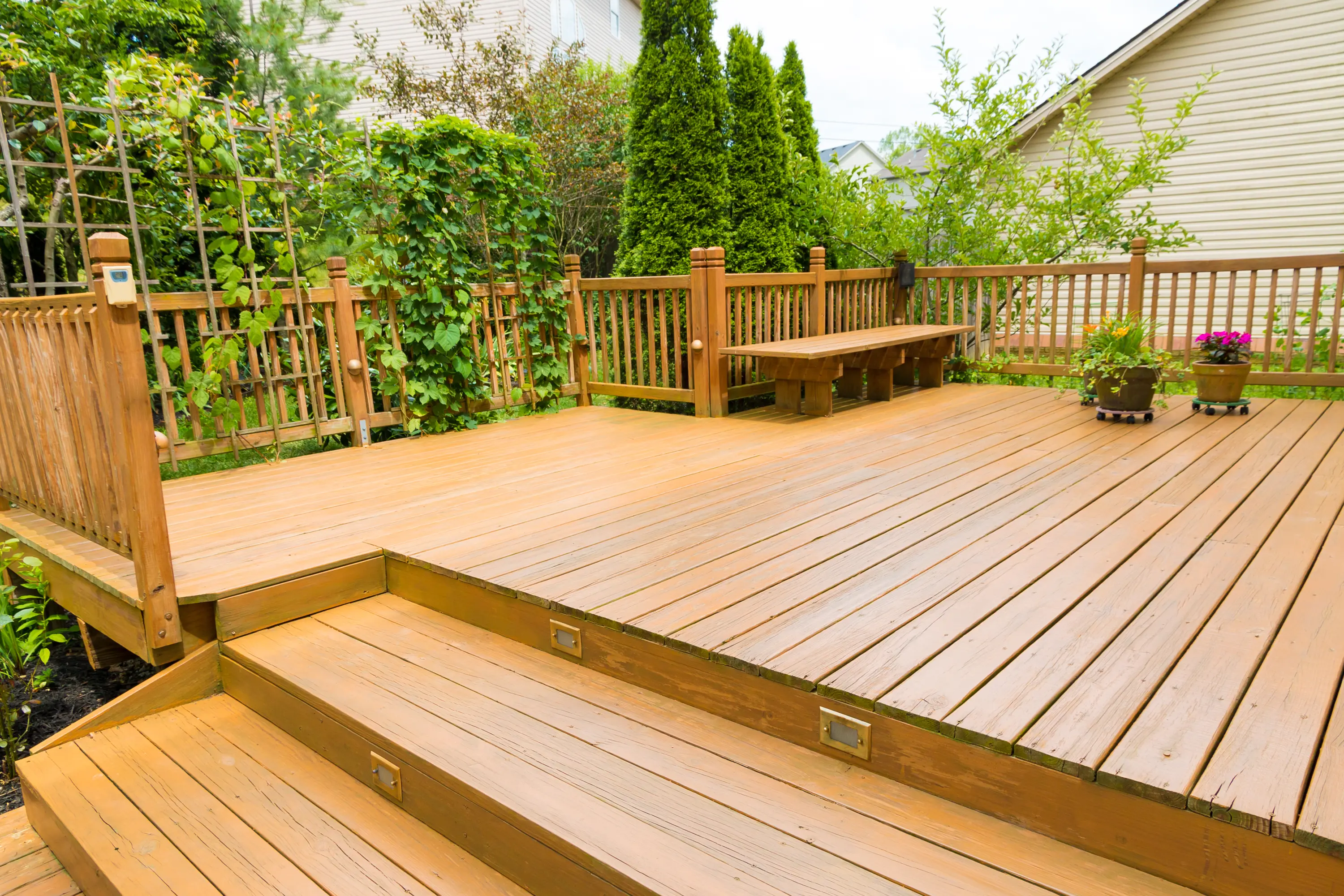 A wooden deck with steps and bench in the background.