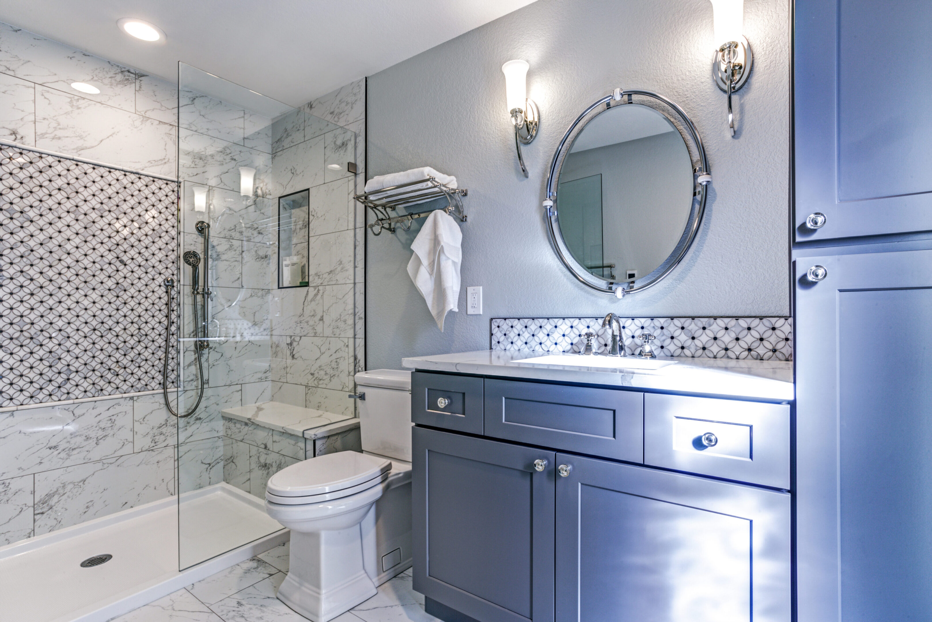 A bathroom with a toilet, sink and mirror.