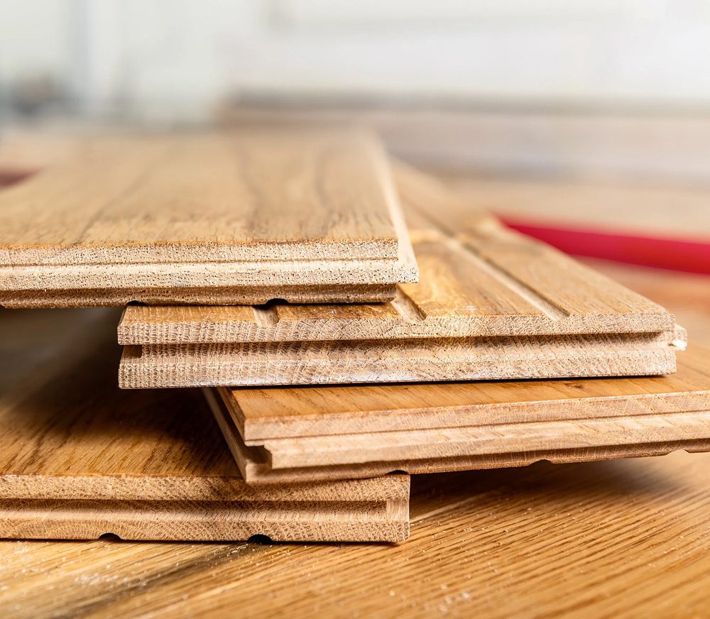 Wooden flooring planks stacked on table.